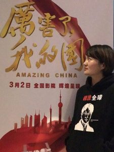Li Wenzu in front of "Amazing China" poster
